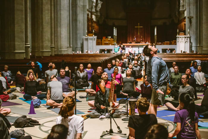 A diverse group of students practice yoga at Grace Cathedral