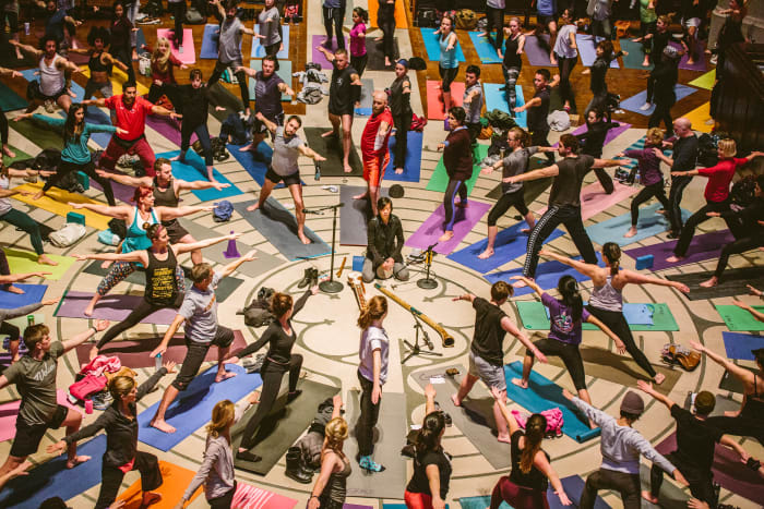 A large group of yogis arranged on the Cathedral labyrinth in Warrior Pose II