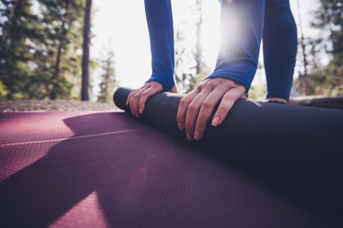 A person rolling up a yoga mat